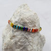 multicolor bracelet draped over a white rock